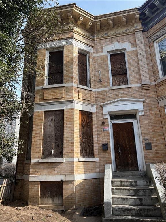 view of front facade featuring brick siding and entry steps