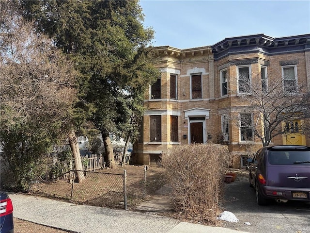 view of front of property featuring brick siding and fence