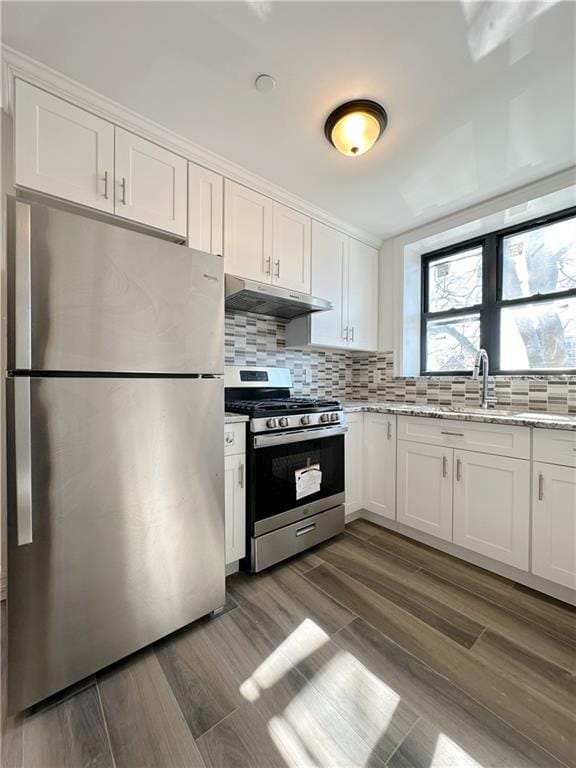 1307 84th St Unit 3C, Brooklyn, NY 11228 - kitchen with stainless steel appliances, under cabinet range hood, white cabinets, and light stone counters