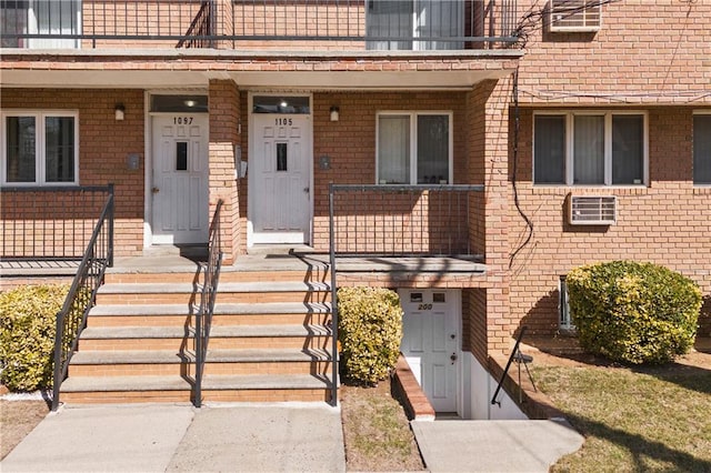 doorway to property featuring brick siding and a balcony