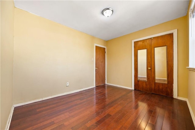 spare room with hardwood / wood-style floors and baseboards