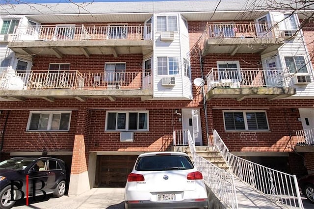 1121 E 73rd St Unit 69, Brooklyn, NY 11234 - view of building exterior with a garage, concrete driveway, and cooling unit