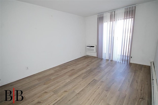 1121 E 73rd St Unit 69, Brooklyn, NY 11234 - spare room featuring plenty of natural light, wood finished floors, a baseboard radiator, and a wall mounted AC