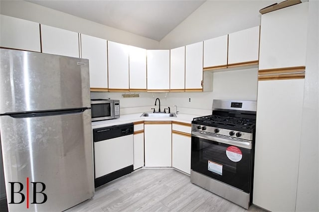 1121 E 73rd St Unit 69, Brooklyn, NY 11234 - kitchen featuring stainless steel appliances, a sink, light wood-type flooring, vaulted ceiling, and light countertops