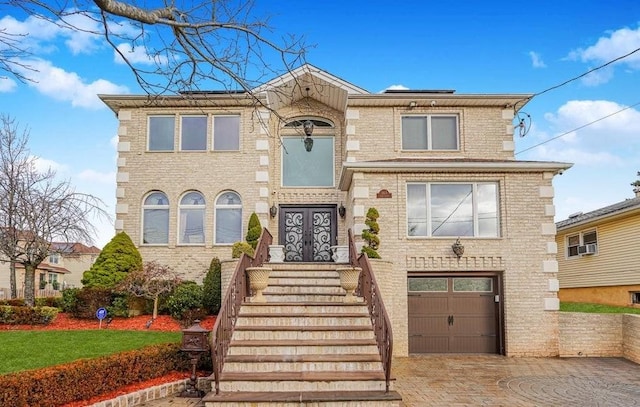 view of front facade with french doors, decorative driveway, a garage, and brick siding