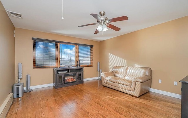 living area with light wood-style flooring, baseboards, visible vents, and a baseboard radiator