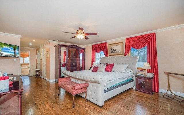 bedroom featuring multiple windows, baseboards, and wood finished floors