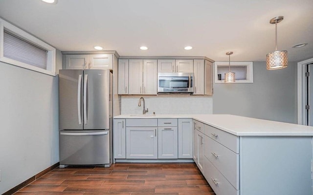 kitchen featuring a sink, appliances with stainless steel finishes, dark wood-style flooring, and gray cabinets