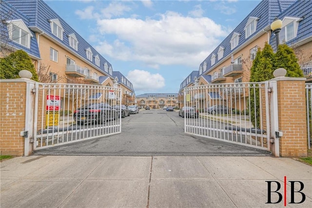 view of road with a residential view, a gated entry, and a gate