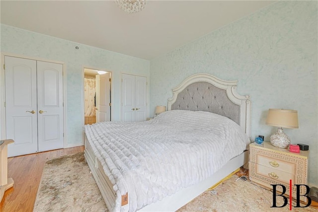 bedroom with connected bathroom and wood finished floors