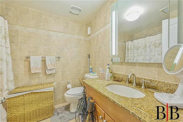 bathroom with curtained shower, tile walls, vanity, and toilet