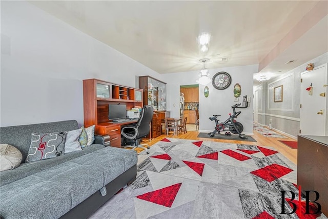 home office with an inviting chandelier, wood finished floors, and baseboards