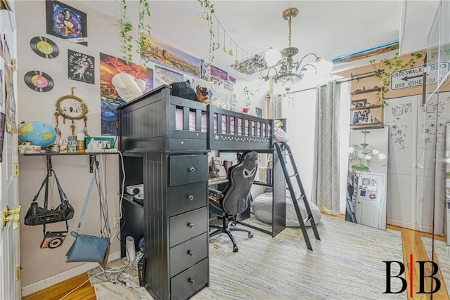 bedroom with baseboards, a notable chandelier, and wood finished floors