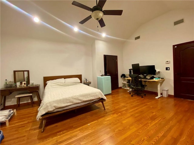 bedroom featuring a ceiling fan, vaulted ceiling, wood finished floors, and visible vents