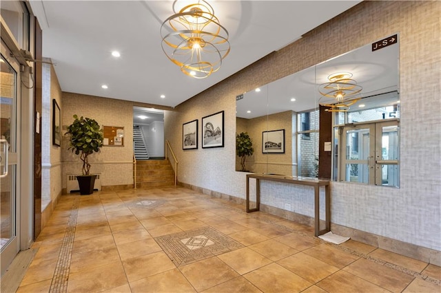 corridor with radiator, light tile patterned floors, wallpapered walls, recessed lighting, and a notable chandelier