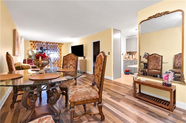 dining room featuring baseboards and light wood finished floors