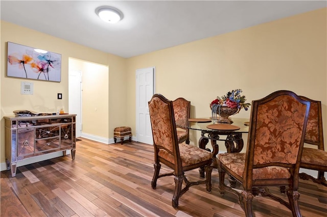 dining space featuring baseboards and wood finished floors