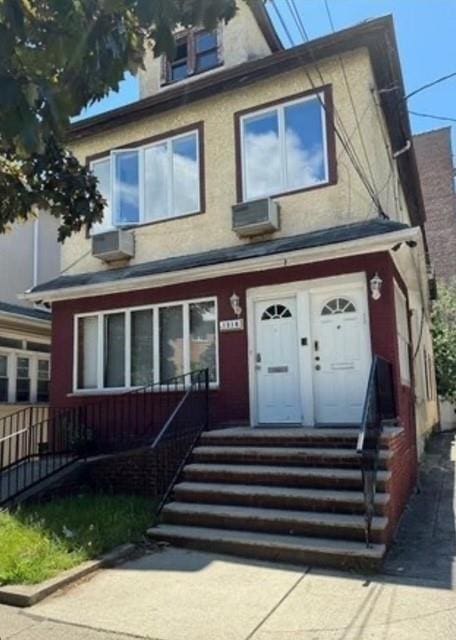 american foursquare style home with an AC wall unit