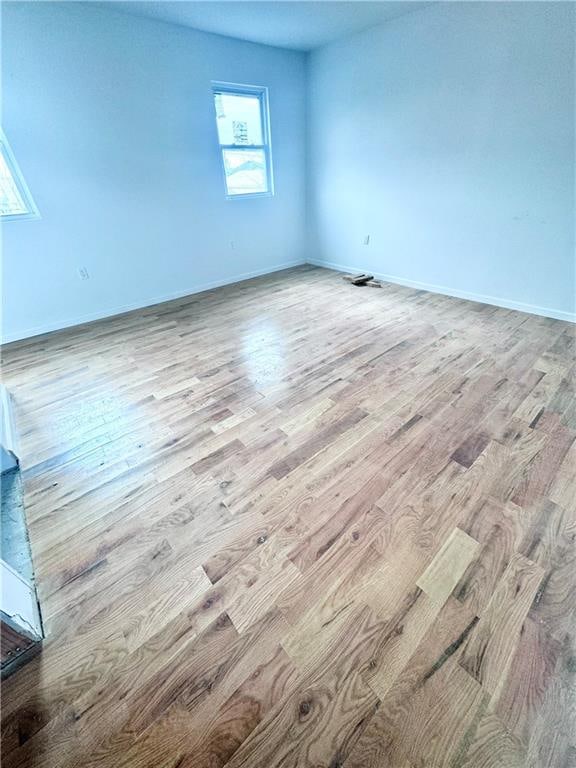 empty room with baseboards and wood finished floors