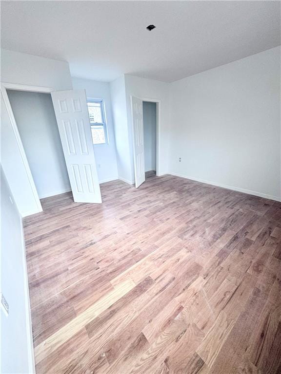 unfurnished room with baseboards and light wood-style floors