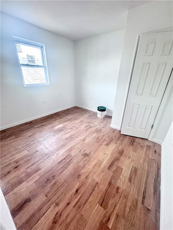 unfurnished room featuring baseboards and light wood finished floors