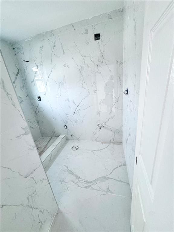 bathroom featuring a marble finish shower