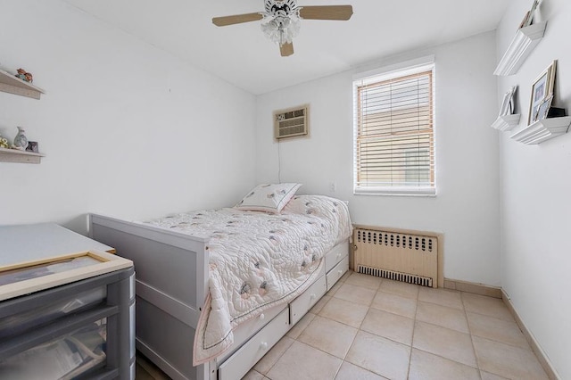 bedroom with a ceiling fan, baseboards, a wall mounted AC, radiator heating unit, and light tile patterned flooring