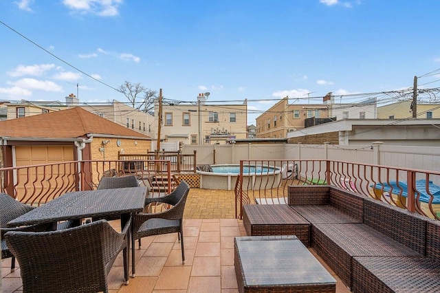 view of patio / terrace featuring a jacuzzi, a fenced in pool, a fenced backyard, and an outdoor hangout area