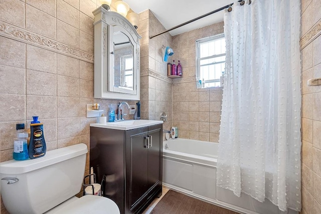 full bathroom featuring toilet, tile walls, vanity, and shower / bath combination with curtain