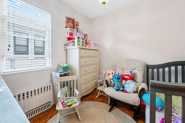 bedroom featuring multiple windows and radiator heating unit