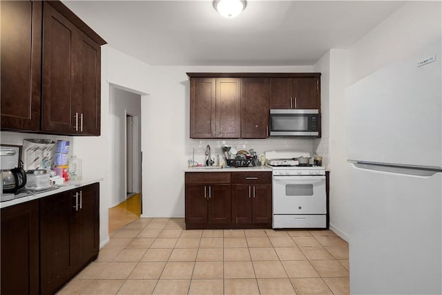 kitchen with white appliances, dark brown cabinets, light countertops, and backsplash