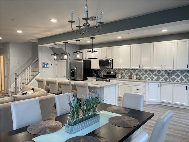 dining room featuring recessed lighting, stairway, visible vents, and light wood-style flooring