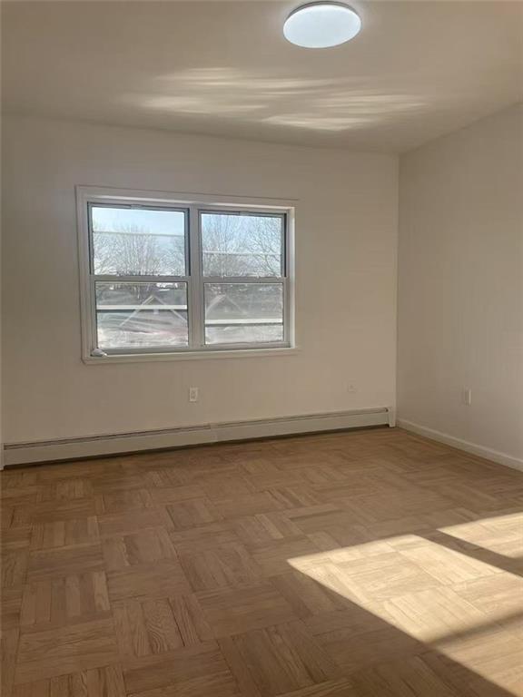 empty room featuring baseboards and baseboard heating