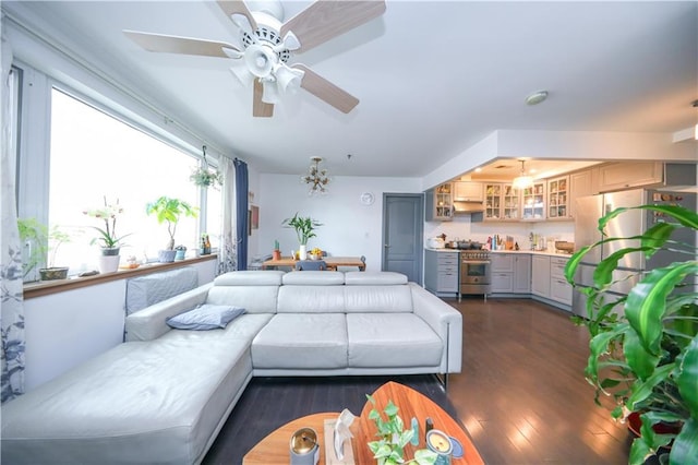 living area with dark wood-type flooring and a ceiling fan