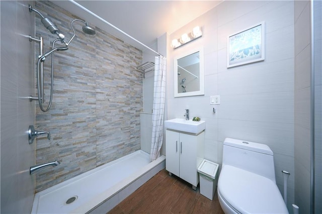 bathroom featuring toilet, a stall shower, vanity, and wood finished floors