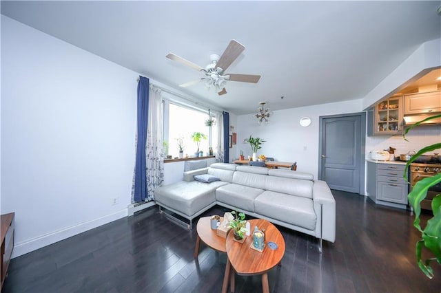 living area with a baseboard heating unit, baseboards, dark wood-type flooring, and ceiling fan