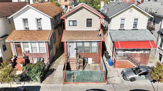 3048 Brighton 4th St, Brooklyn, NY 11235 - traditional-style house featuring a residential view, entry steps, brick siding, and a shingled roof