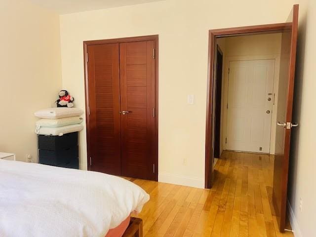 bedroom featuring a closet, baseboards, and light wood finished floors