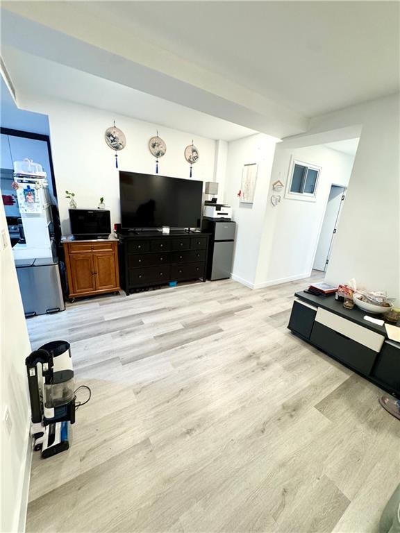 living area with baseboards and light wood finished floors