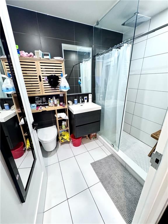 bathroom featuring tile patterned flooring, toilet, vanity, and a stall shower