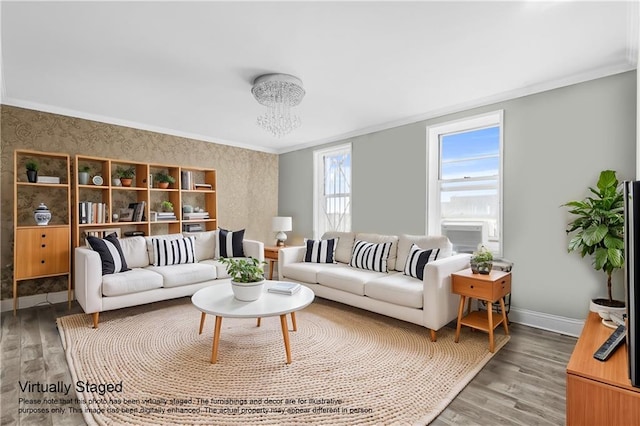 living area with baseboards, a notable chandelier, ornamental molding, and light wood finished floors