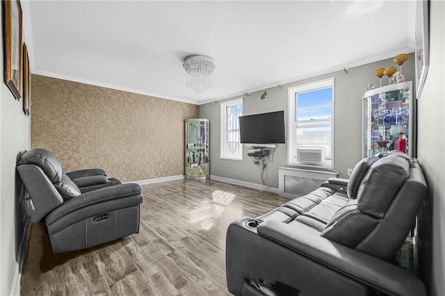 living room featuring cooling unit, baseboards, wallpapered walls, ornamental molding, and light wood-type flooring