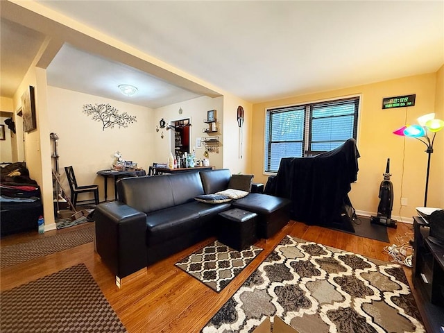 living area with baseboards and wood finished floors