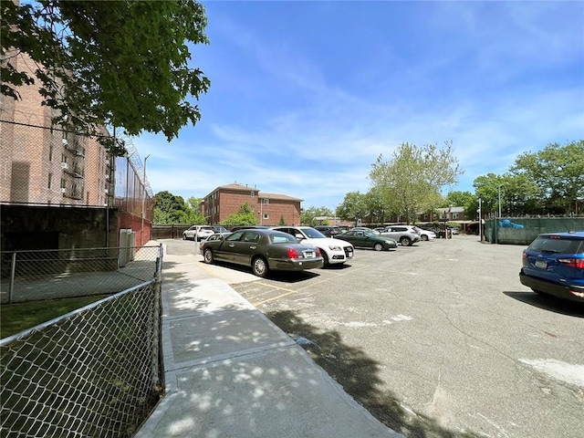 uncovered parking lot featuring fence