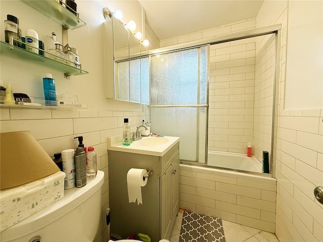 bathroom featuring tile patterned flooring, tile walls, vanity, and tiled shower / bath combo