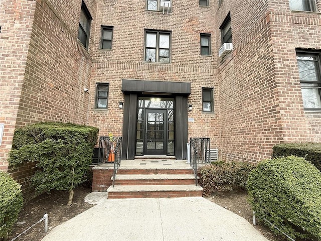 entrance to property featuring cooling unit and brick siding