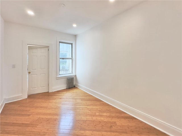 1708 Linden St, Ridgewood, NY 11385 - empty room with radiator heating unit, light wood-type flooring, and recessed lighting