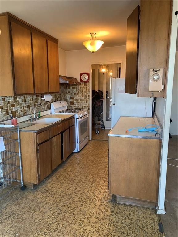 2652 Cropsey Ave Unit 15K, Brooklyn, NY 11214 - kitchen featuring white appliances, decorative backsplash, exhaust hood, light countertops, and brown cabinetry