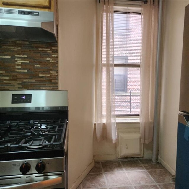 590 Parkside Ave Unit 2Be, Brooklyn, NY 11226 - kitchen featuring gas stove, under cabinet range hood, tasteful backsplash, and baseboards