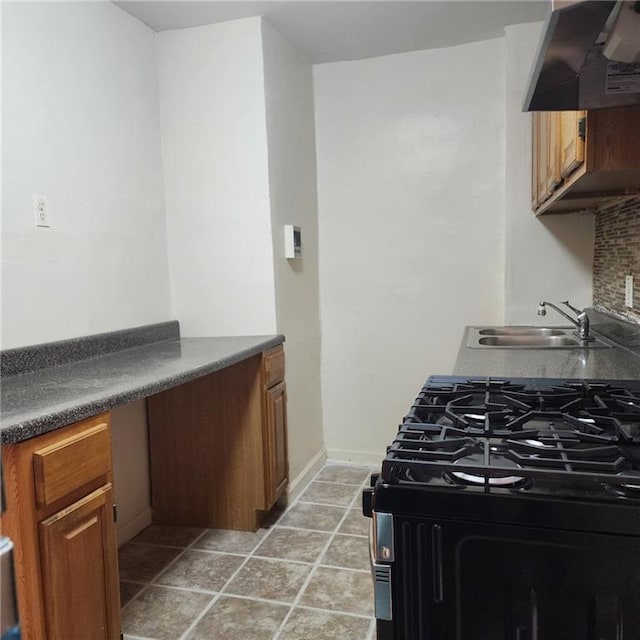 590 Parkside Ave Unit 2Be, Brooklyn, NY 11226 - kitchen with wall chimney range hood, black range with gas stovetop, a sink, dark countertops, and brown cabinetry